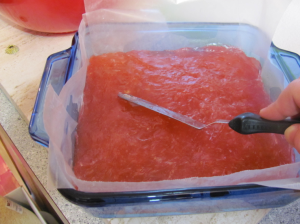 After adding the three drops of red food coloring and the Rose Water, I poured (scooped) the mixture into the wax lined/oiled pan. I used this handy icing spatula to spread it out even. 